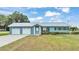 Ranch style home with attached two-car garage, landscaping and a metal roof at 6110 Downing St, Dover, FL 33527