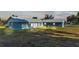 Rear view of a blue house with metal roof and garage at 6110 Downing St, Dover, FL 33527