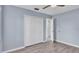 Bedroom with gray walls, wood-look floors, and double closet at 6110 Downing St, Dover, FL 33527