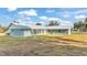 Rear view of a blue house with metal roof and garage at 6110 Downing St, Dover, FL 33527