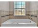 Bathroom with a large garden tub and window at 6110 Downing St, Dover, FL 33527