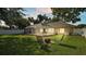Lush backyard featuring a screened-in pool area, fire pit, and ample green space for outdoor enjoyment at 23338 Duchess Ave, Port Charlotte, FL 33954
