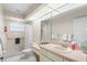 Well-lit bathroom featuring a large mirror, a vanity, and a shower with a grab bar at 23338 Duchess Ave, Port Charlotte, FL 33954