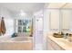 Bright bathroom features a tub under a window and a separate glass-enclosed shower at 23338 Duchess Ave, Port Charlotte, FL 33954