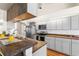 Modern kitchen features updated cabinets, stainless steel appliances, wood countertops, and stylish backsplash at 23338 Duchess Ave, Port Charlotte, FL 33954