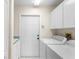 Bright laundry room with white cabinets, a utility sink, and modern appliances at 23338 Duchess Ave, Port Charlotte, FL 33954