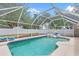 Screened-in pool with lounge chairs and pool toys, perfect for relaxing and enjoying the outdoors at 23338 Duchess Ave, Port Charlotte, FL 33954
