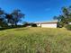 Exterior view of one-story home with screened porch from grassy yard at 2209 Jerri Lynn Ct, Plant City, FL 33567