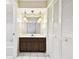 Bathroom with wood vanity, large mirror, and a linen closet at 2209 Jerri Lynn Ct, Plant City, FL 33567