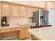Kitchen with light wood cabinets, stainless steel refrigerator, and ample counter space at 10507 Goldwater Ln, Riverview, FL 33569