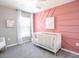 Charming Bedroom with pink accent wall and crib at 2560 58Th E Cir, Palmetto, FL 34221