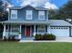 Two-story house with blue siding, red door, and a white garage at 6704 N 13Th St, Tampa, FL 33604