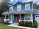 Two-story house with blue siding, red door, and a white porch at 6704 N 13Th St, Tampa, FL 33604