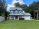Two-story house with blue siding, red door, and a well-maintained lawn at 6704 N 13Th St, Tampa, FL 33604