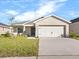 Newly constructed home with a two-car garage and well-manicured lawn at 35591 Bellington Blvd, Zephyrhills, FL 33541