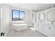 Luxurious bathroom with double vanity, soaking tub, and marble tile at 116 Wimbledon Ct, Redington Shores, FL 33708