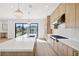 Modern kitchen with light wood cabinets and a large island at 116 Wimbledon Ct, Redington Shores, FL 33708