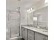 Bright bathroom featuring dual vanities, granite countertops, and a walk-in shower at 7011 161St E Ter, Parrish, FL 34219