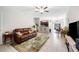 Open living room with tile floors, brown leather couch, and a view into the kitchen and dining area at 7209 Sweet Alyssum Ct, Tampa, FL 33619