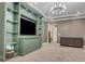 Media room with custom cabinetry, a large TV, and a chandelier at 10469 Meadowrun Dr, Lithia, FL 33547