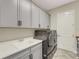 Laundry room with gray cabinets, quartz countertop and new washer/dryer at 10469 Meadowrun Dr, Lithia, FL 33547