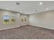 Spacious bonus room with neutral carpeting and arched windows at 10469 Meadowrun Dr, Lithia, FL 33547