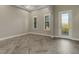 Bright room with herringbone floors and plantation shutters on large windows at 10469 Meadowrun Dr, Lithia, FL 33547