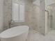 Elegant bathroom with soaking tub, walk-in shower, and marble tile at 10469 Meadowrun Dr, Lithia, FL 33547