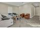 Open living area with herringbone floors, a sectional sofa, and two armchairs at 10469 Meadowrun Dr, Lithia, FL 33547