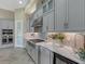 Modern kitchen with gray cabinets, stainless steel appliances, and quartz countertops at 10469 Meadowrun Dr, Lithia, FL 33547