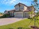 Two-story home with tile roof, double garage, and manicured lawn at 10469 Meadowrun Dr, Lithia, FL 33547