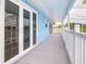 Spacious covered deck with gray wood floors and white railing at 5260 42Nd S St, St Petersburg, FL 33711