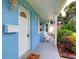 Charming light-blue home with a covered front porch, white door, and manicured landscaping at 5260 42Nd S St, St Petersburg, FL 33711