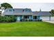 Charming blue home featuring dormer windows, a well-manicured lawn, and an attached garage at 5260 42Nd S St, St Petersburg, FL 33711