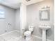 Updated bathroom with pedestal sink, toilet and tiled floor at 8613 Beth Ct, Odessa, FL 33556