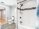 Clean bathroom with toilet, bathtub and shower, and updated tile at 8613 Beth Ct, Odessa, FL 33556