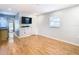 Bright bedroom with wood flooring, large window, and mounted TV at 8613 Beth Ct, Odessa, FL 33556