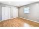 Bright bedroom with light gray walls, wood flooring, and double closets at 8613 Beth Ct, Odessa, FL 33556