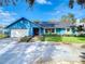 Ranch style home with blue exterior, white garage door, and well-manicured lawn at 8613 Beth Ct, Odessa, FL 33556