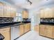 Modern kitchen with light wood cabinets, granite counters, and stainless steel appliances at 8613 Beth Ct, Odessa, FL 33556