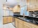 Modern kitchen with light wood cabinets, granite counters, and stainless steel appliances at 8613 Beth Ct, Odessa, FL 33556