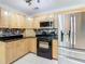 Modern kitchen with light wood cabinets, granite counters, and stainless steel appliances at 8613 Beth Ct, Odessa, FL 33556