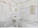 All white bathroom with marble tiling, pedestal sink, tub and stained glass window at 4317 S Trask St, Tampa, FL 33611