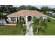 Single-story house with a light green exterior, brown roof, and palm trees at 2638 E Knights Griffin Rd Rd, Plant City, FL 33565