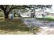 Exterior of home showcasing a well-maintained yard, parking and mature trees at 2638 E Knights Griffin Rd Rd, Plant City, FL 33565