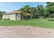 Sprawling front yard and exterior of home featuring mature trees and gravel drive at 2638 E Knights Griffin Rd Rd, Plant City, FL 33565