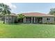 Expansive front yard view of a ranch style home with meticulous landscaping and mature palm trees at 2638 E Knights Griffin Rd Rd, Plant City, FL 33565