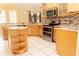 Modern kitchen featuring stainless steel appliances, granite countertops, and light wood cabinets, offering ample storage at 2638 E Knights Griffin Rd Rd, Plant City, FL 33565