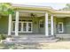 Spacious covered patio with white pillars, ceiling fan, and access to the home via glass doors at 2638 E Knights Griffin Rd Rd, Plant City, FL 33565