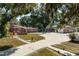 Brick home with a walkway and mature trees. Detached garage in the background at 4911 W Sam Allen Rd, Plant City, FL 33565
